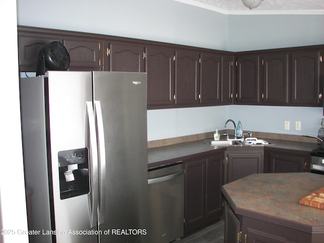 kitchen with crown molding, appliances with stainless steel finishes, sink, and dark brown cabinets