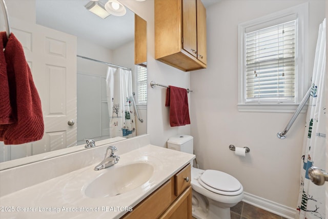 bathroom with vanity, a wealth of natural light, tile patterned floors, and toilet