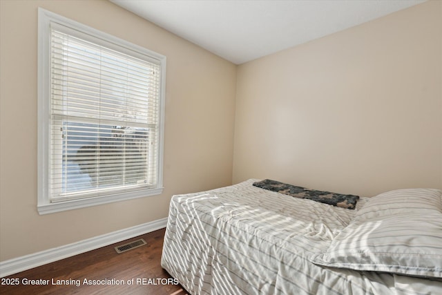 bedroom with dark hardwood / wood-style flooring