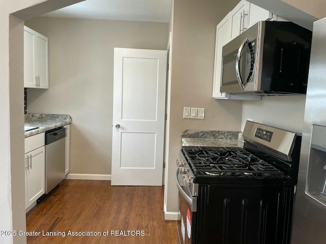 kitchen featuring white cabinetry, stainless steel appliances, dark hardwood / wood-style flooring, and light stone counters