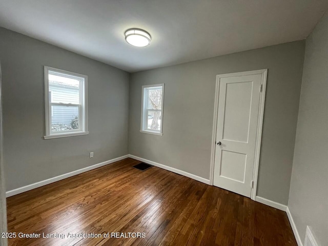 spare room featuring dark wood-type flooring