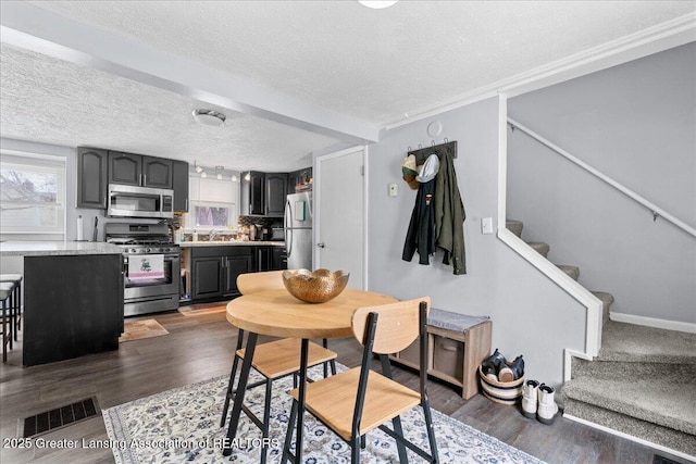 dining area featuring dark hardwood / wood-style flooring, sink, and a textured ceiling