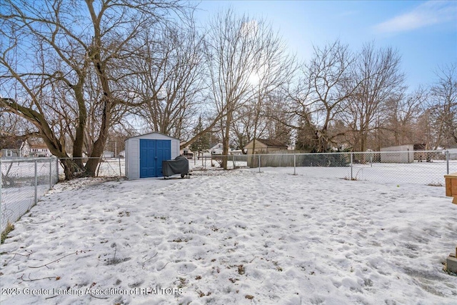 yard covered in snow featuring a shed