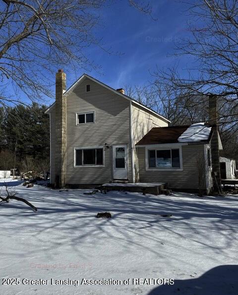 view of snow covered rear of property