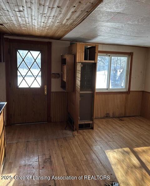 entrance foyer featuring wood-type flooring, wooden walls, and wooden ceiling