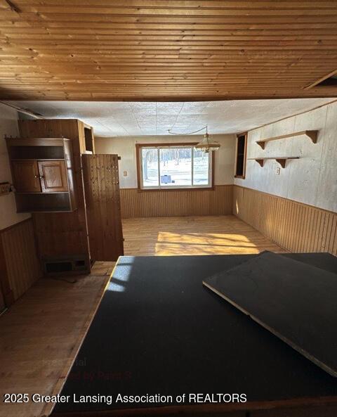 basement featuring wooden ceiling and wooden walls