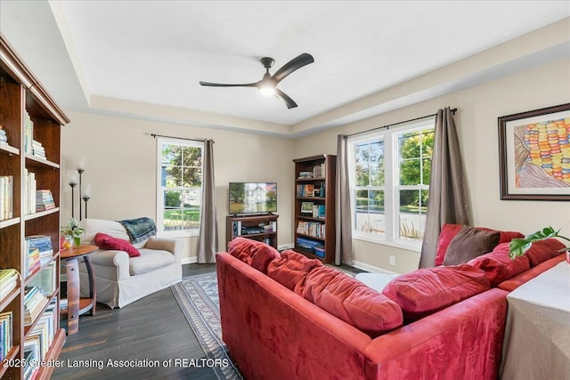 living area featuring dark wood-type flooring and ceiling fan