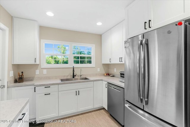 kitchen with white cabinetry, stainless steel appliances, and sink