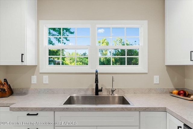 kitchen featuring white cabinetry, sink, and a wealth of natural light