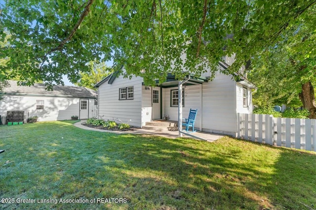 rear view of property featuring a lawn