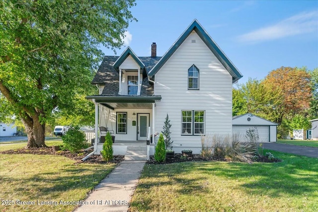 view of front property with a garage, an outdoor structure, covered porch, and a front lawn