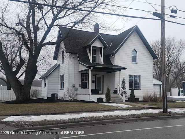 cape cod-style house with a porch, a front lawn, and central air condition unit