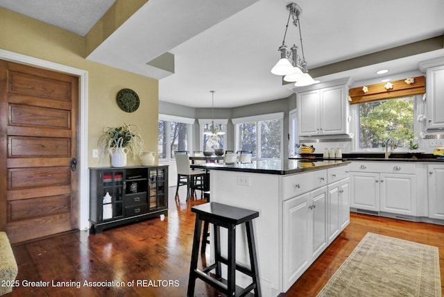 kitchen featuring pendant lighting, white cabinets, and a kitchen breakfast bar