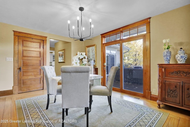 dining area featuring a notable chandelier and light hardwood / wood-style flooring