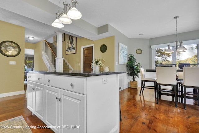 kitchen featuring hanging light fixtures, white cabinetry, a center island, and dark hardwood / wood-style floors