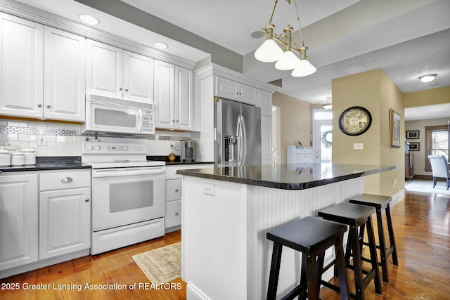 kitchen featuring white cabinetry, white appliances, tasteful backsplash, and light hardwood / wood-style floors