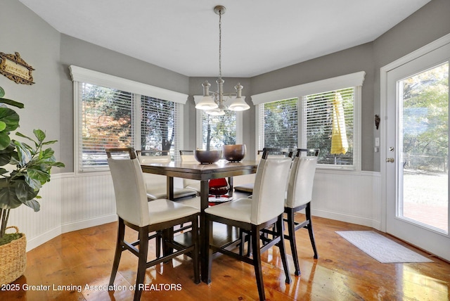 dining space featuring hardwood / wood-style floors and a chandelier