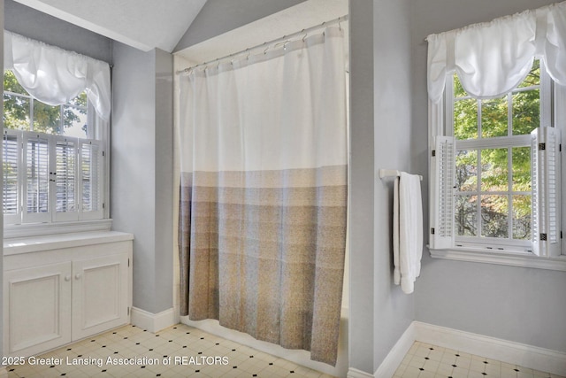 bathroom featuring lofted ceiling