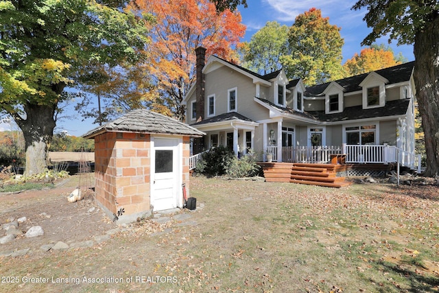 rear view of property with a storage shed