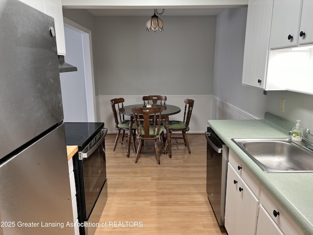 kitchen featuring stainless steel appliances, white cabinetry, sink, and light hardwood / wood-style floors