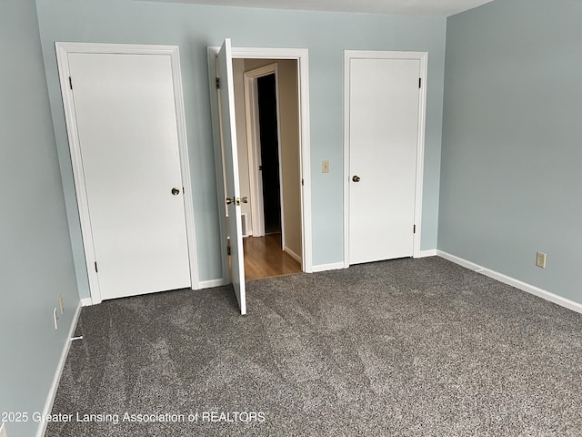 unfurnished bedroom with dark carpet