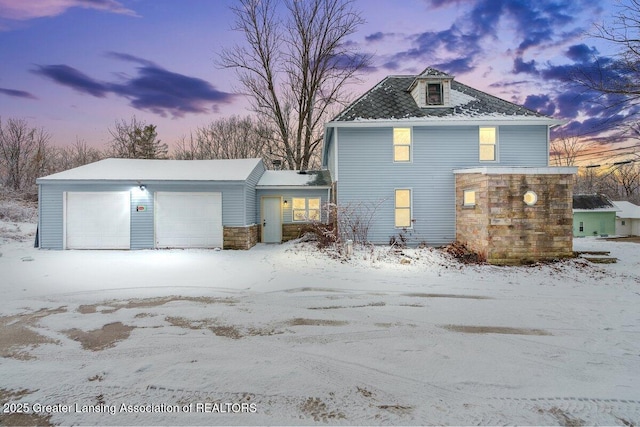 view of snowy exterior featuring a garage