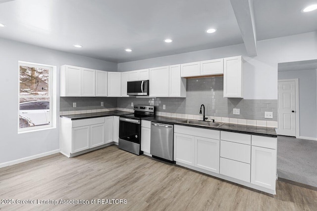 kitchen featuring appliances with stainless steel finishes, light hardwood / wood-style floors, sink, and white cabinets