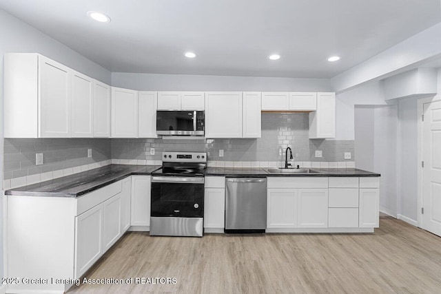 kitchen featuring white cabinetry, appliances with stainless steel finishes, light hardwood / wood-style floors, and sink