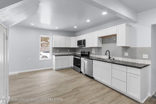 kitchen featuring white cabinetry, sink, stainless steel appliances, and light hardwood / wood-style floors