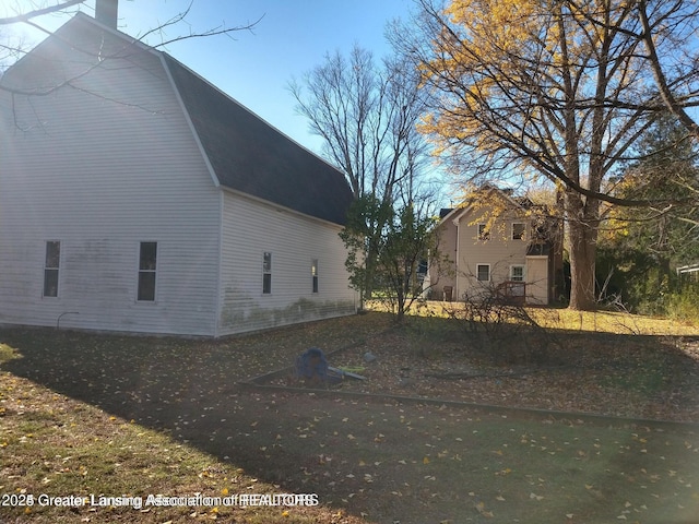 view of side of home with a gambrel roof