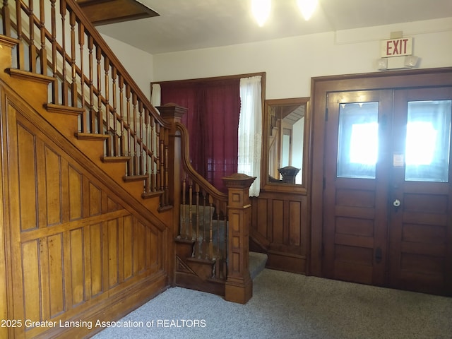 carpeted foyer entrance featuring stairway