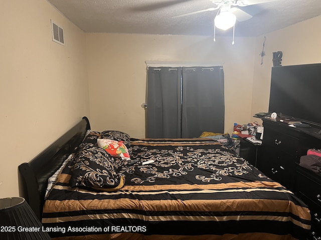 bedroom with a textured ceiling and ceiling fan