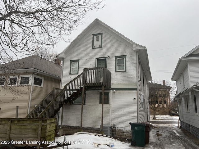 snow covered rear of property with central AC