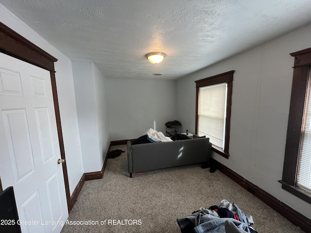 bedroom with light colored carpet and a textured ceiling