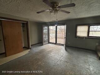 spare room featuring ceiling fan, a wealth of natural light, and a textured ceiling