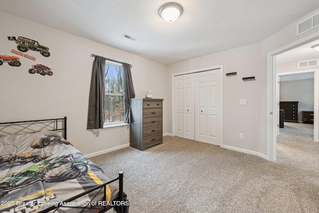 bedroom featuring carpet floors, a textured ceiling, and a closet