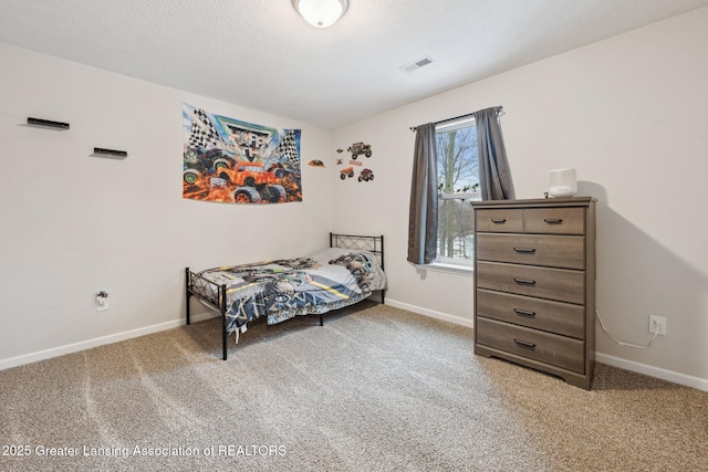 bedroom with carpet floors and a textured ceiling