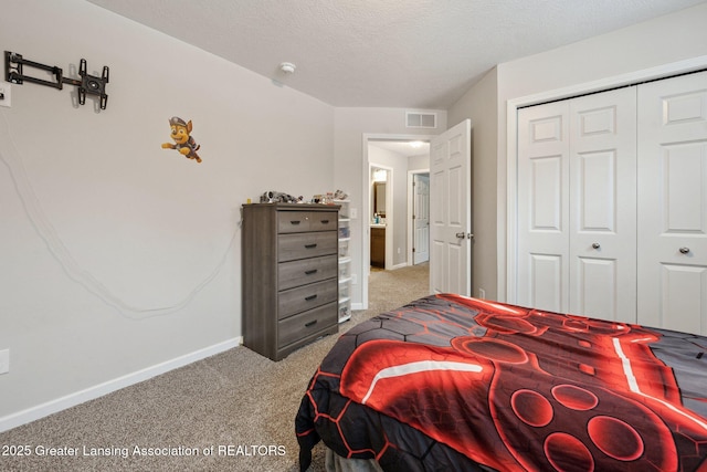 bedroom featuring light colored carpet, a textured ceiling, and a closet