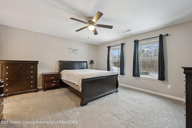 carpeted bedroom with ceiling fan and a textured ceiling