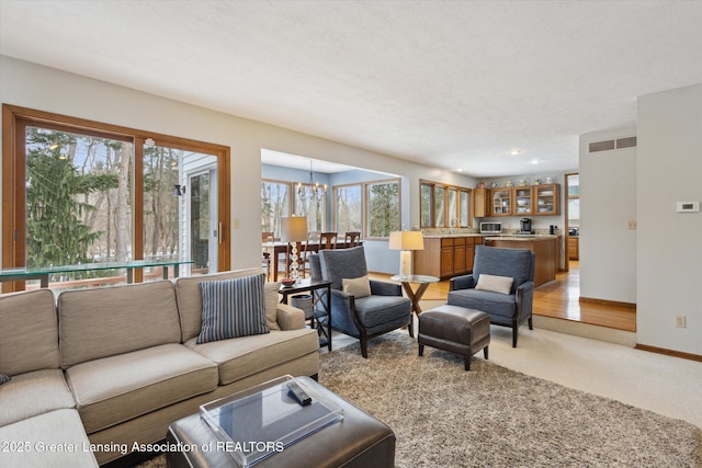 carpeted living room featuring a textured ceiling and a chandelier