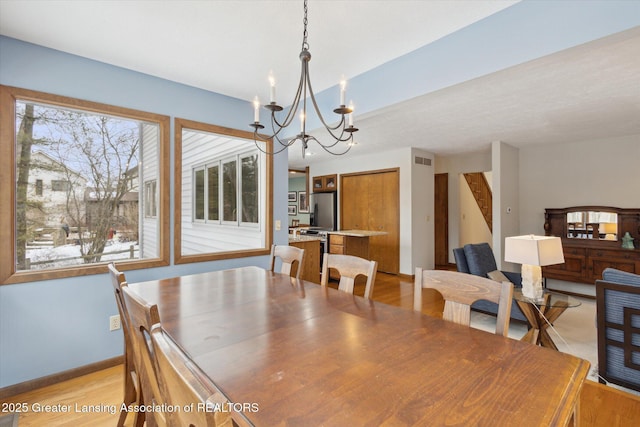 dining space with an inviting chandelier and light hardwood / wood-style floors