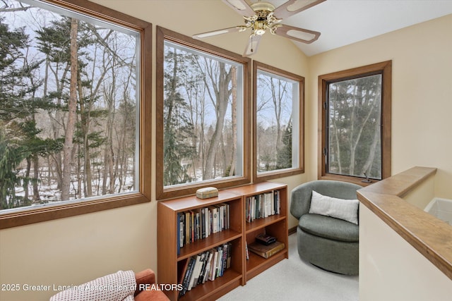 sunroom / solarium with vaulted ceiling, plenty of natural light, and ceiling fan