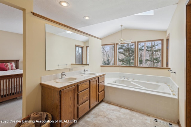 bathroom featuring vanity, vaulted ceiling, tiled bath, and ceiling fan