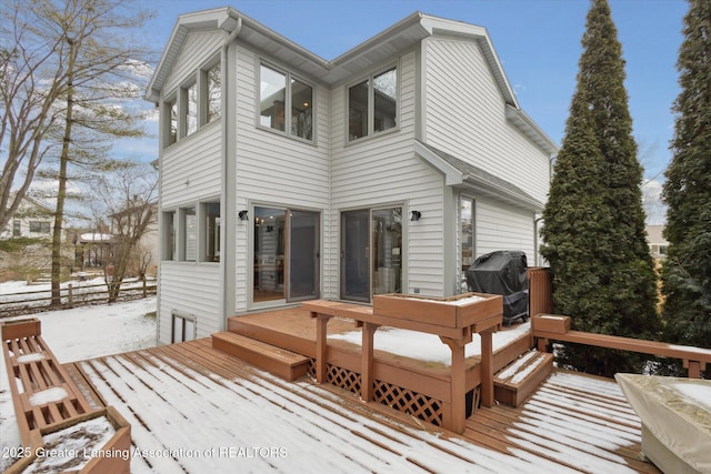 snow covered rear of property featuring a wooden deck