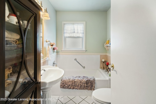 bathroom featuring toilet and a tub to relax in