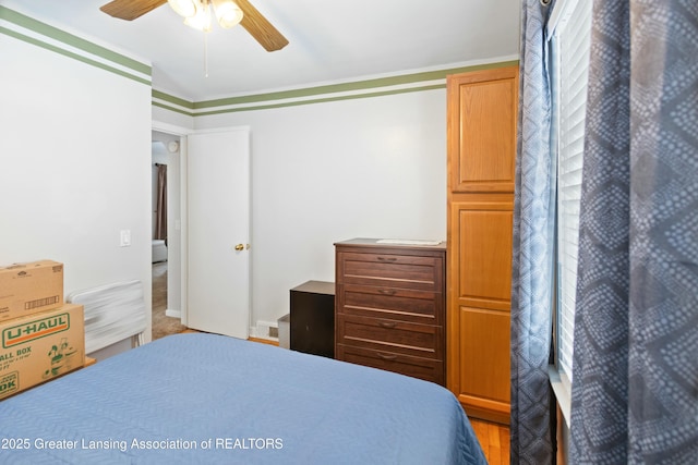 bedroom featuring ceiling fan, ornamental molding, and light hardwood / wood-style flooring