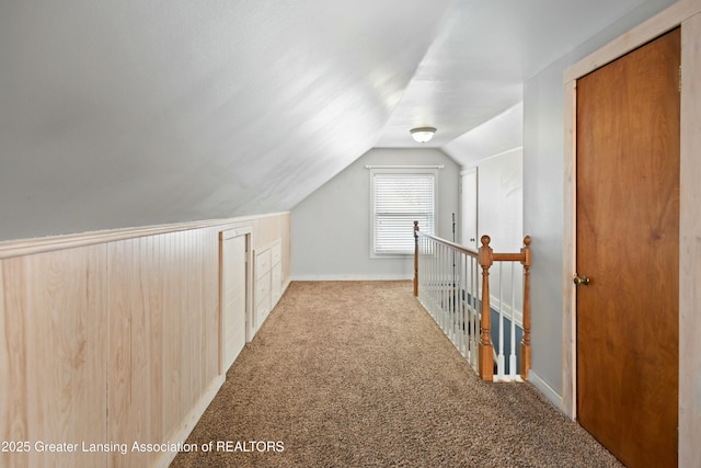 bonus room with lofted ceiling and light colored carpet