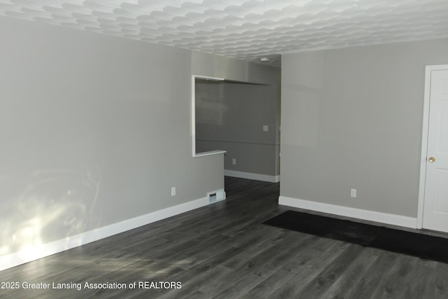 spare room with dark wood-type flooring and a textured ceiling