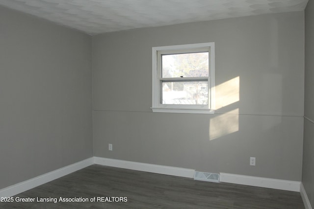 spare room with dark hardwood / wood-style flooring