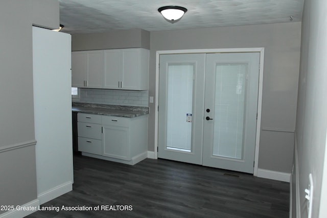 kitchen featuring white cabinetry, dark hardwood / wood-style flooring, french doors, and backsplash